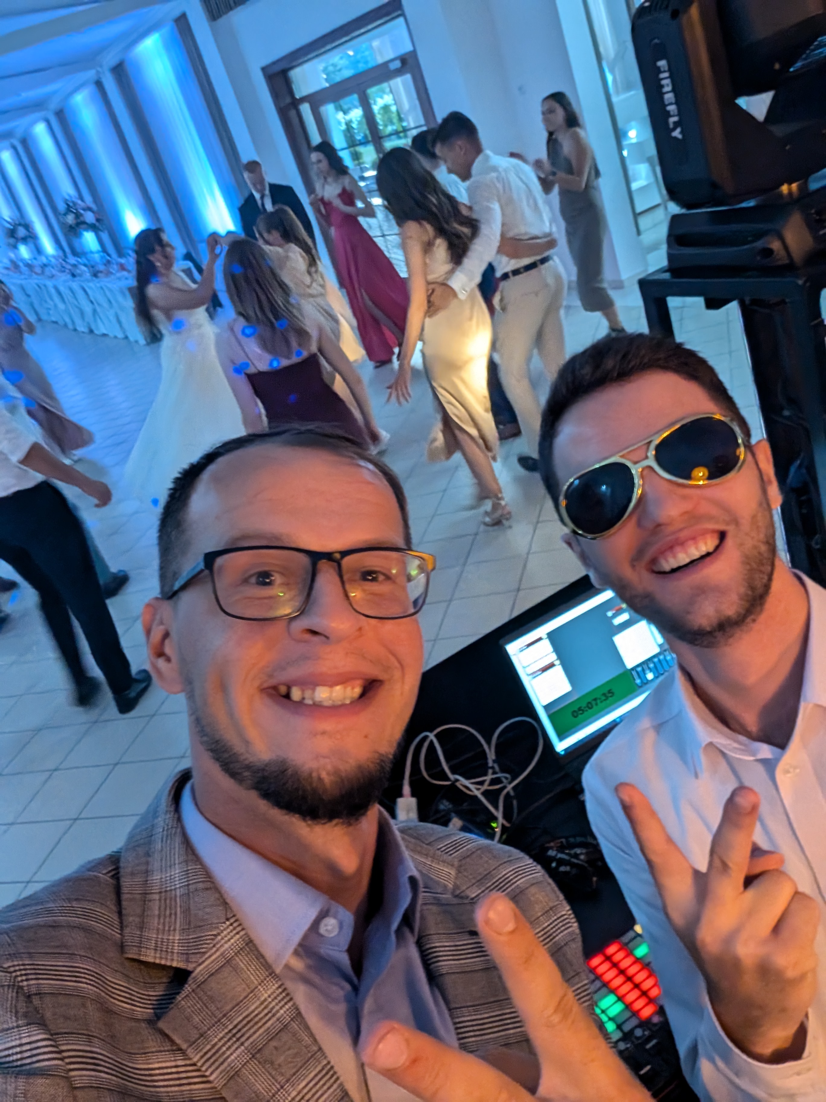 Selfie DJ-ów Novussteam podczas wesela z tańczącymi gośćmi w tle