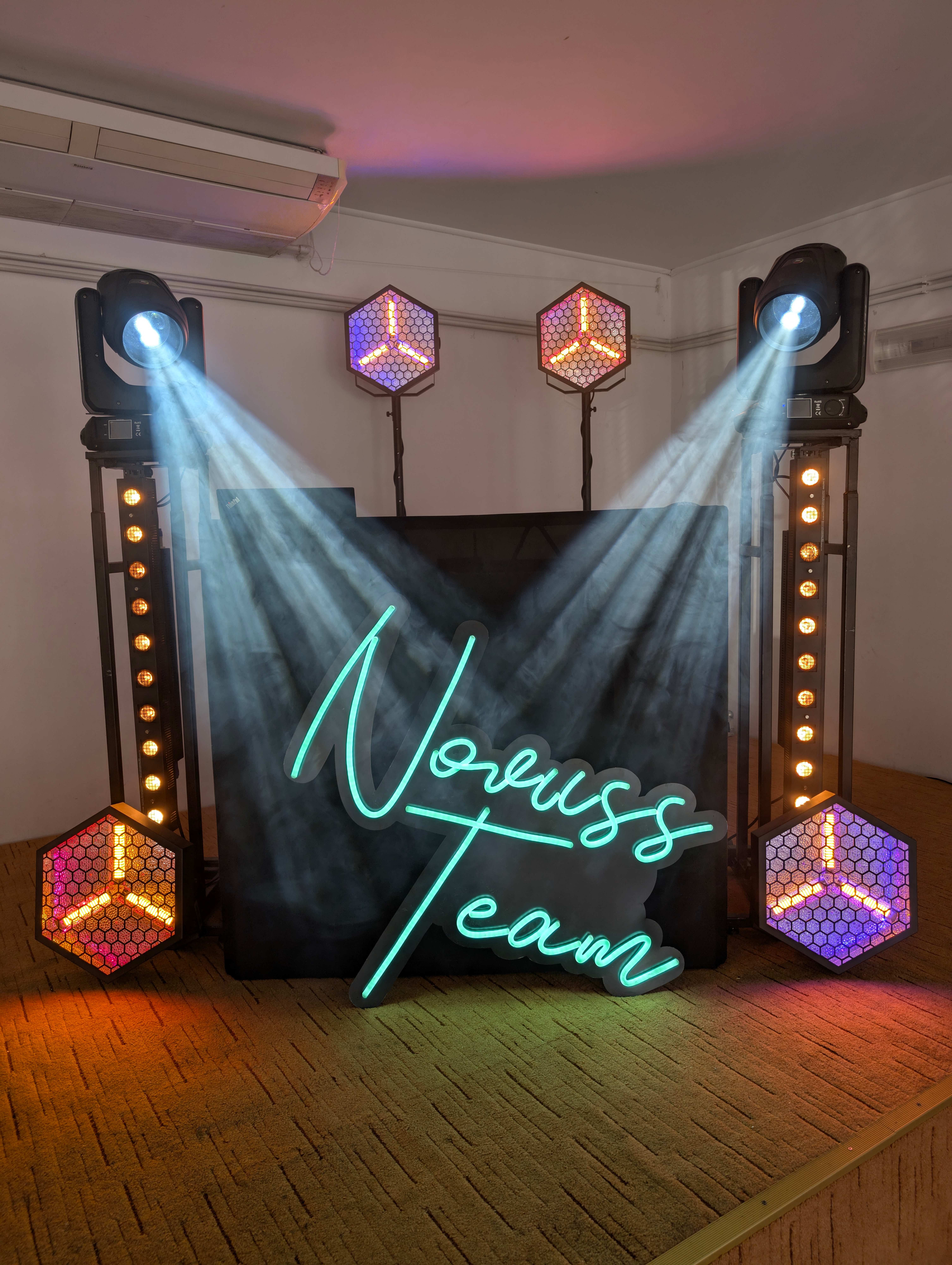 Dramatyczny setup z neonowym logo i kolorowymi efektami heksagonalnymi