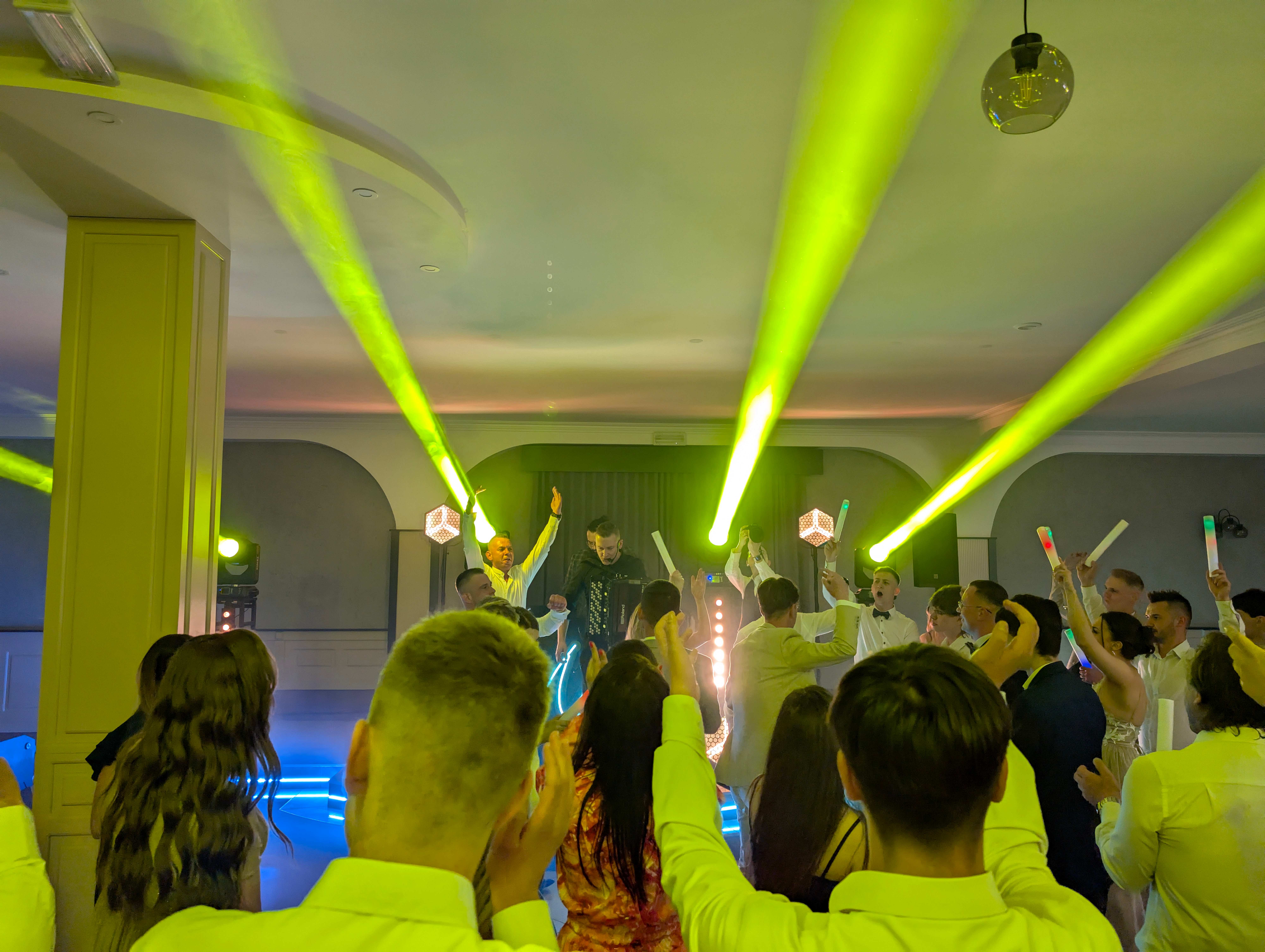 Energetyczna impreza z zielonymi efektami świetlnymi i świętującymi gośćmi