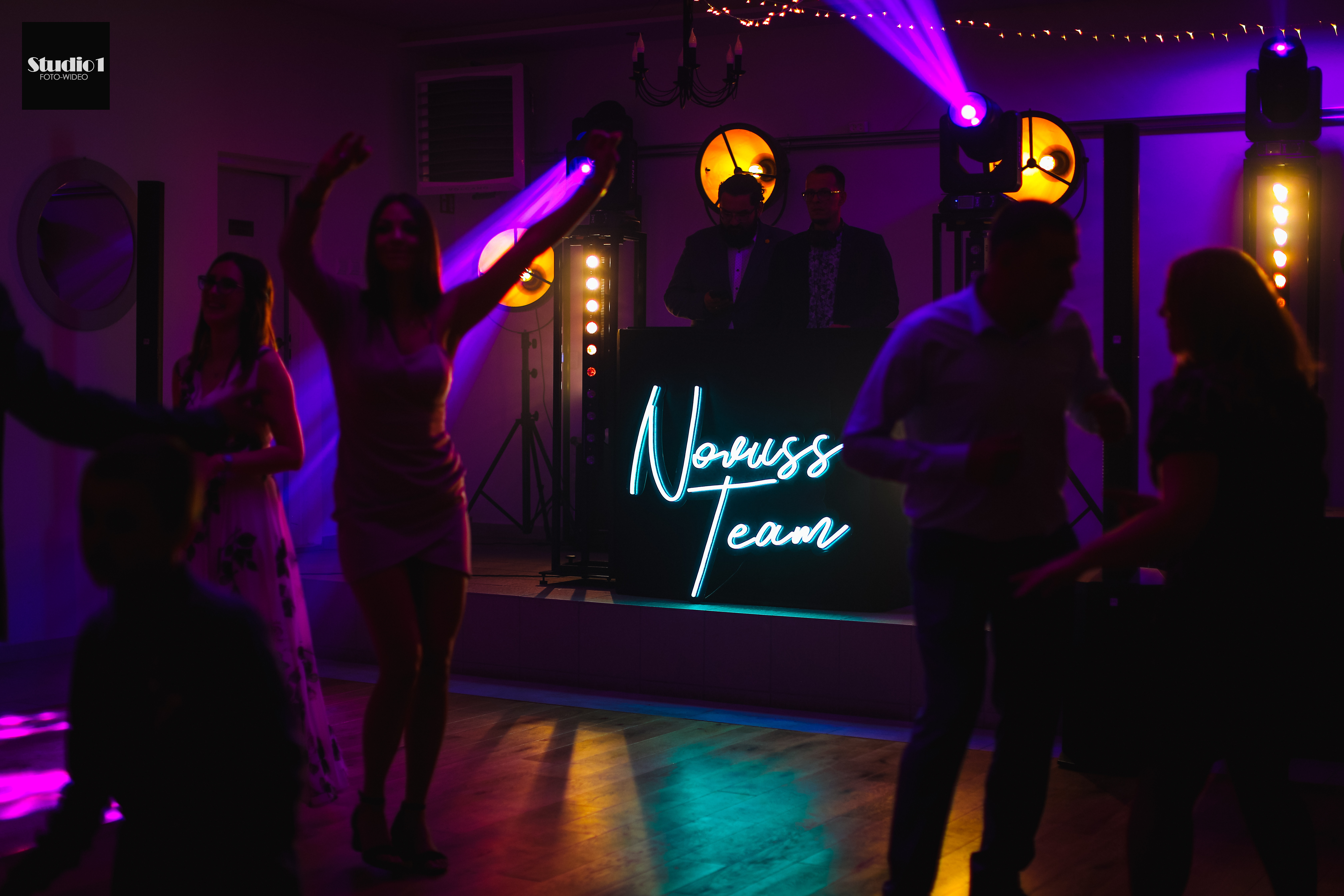 Atmosfera weselna z tańczącymi gośćmi i kolorowym oświetleniem