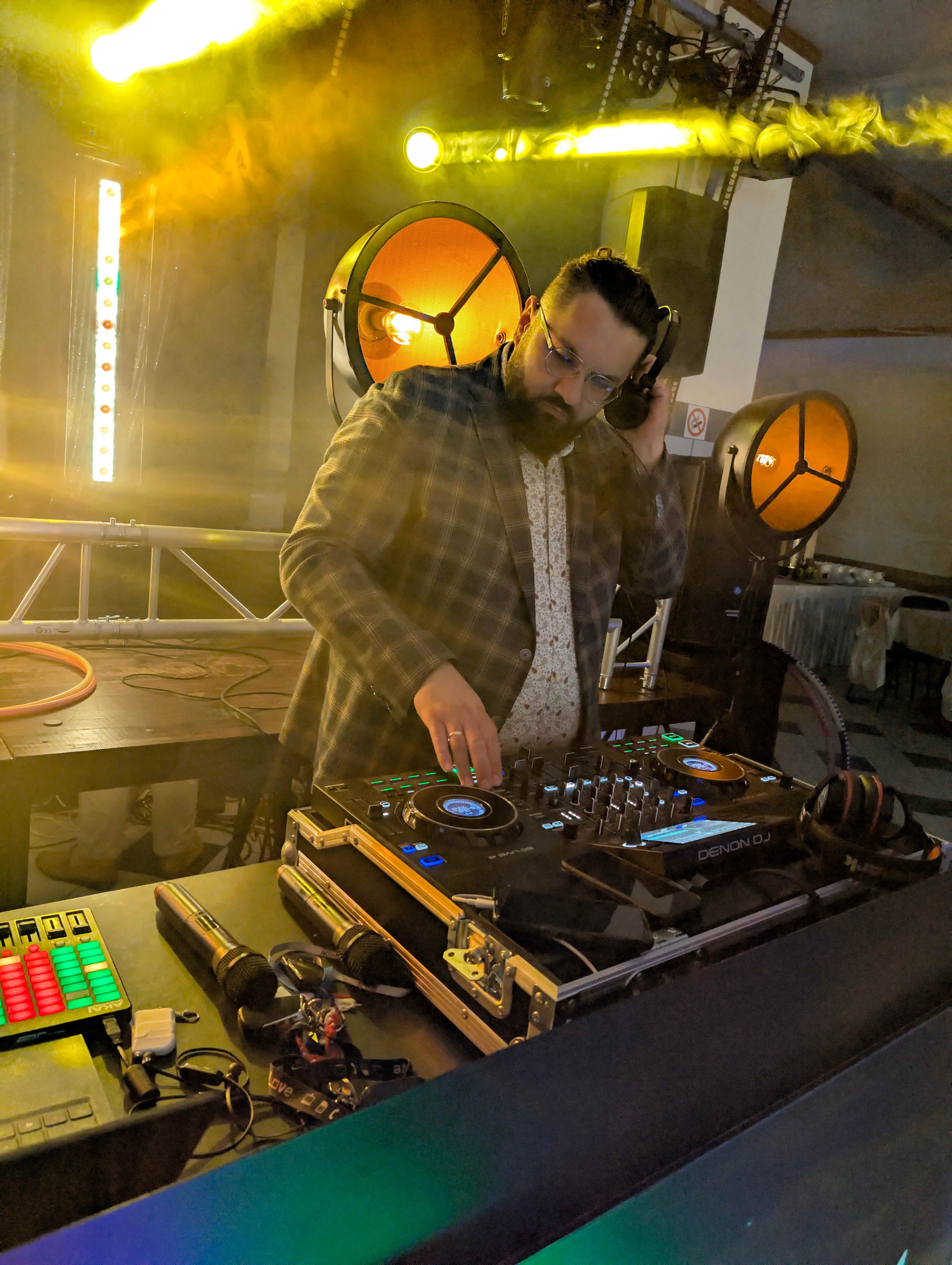 DJ występujący z dramatycznym żółto-zielonym oświetleniem i efektami dymu
